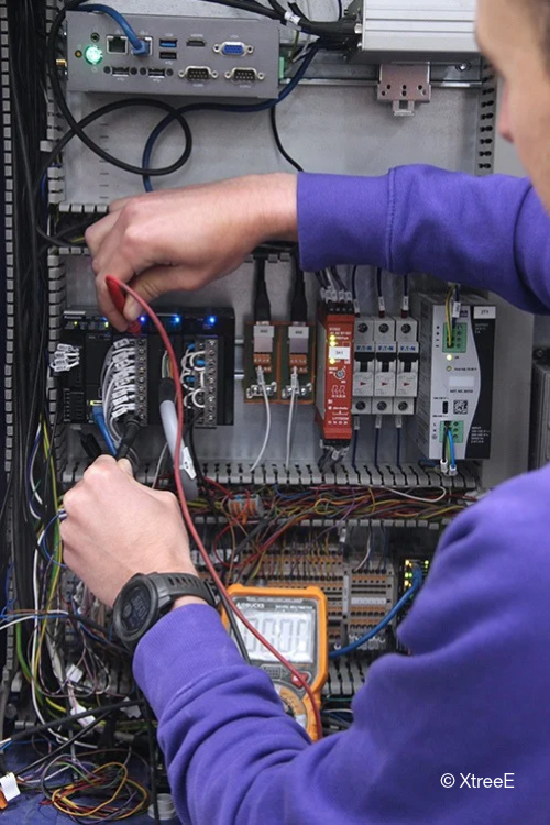 XtreeE technician commissioning the control cabinet housing the Panasonic Industry components